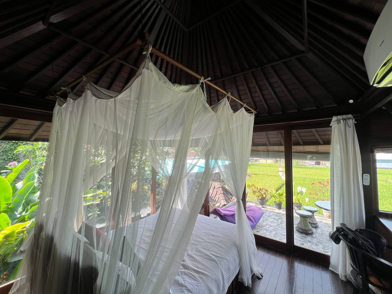 A bright bedroom beneath a traditional roof, opening onto the terrace